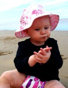 Pea pod cloth nappies-Baby sitting in the sand at the beach wearing pea pod cloth nappy
