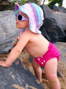 Pea pod cloth nappies-Baby standing by rocks wearing Pea Pod cloth nappy