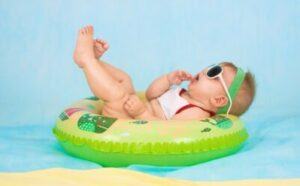 Best Infant Sunglasses-Baby with sunglasses swimming in a donut.