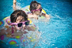 Best infant sunglasses-two girls swimming with sunglasses