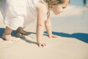 5 benefits organic cotton have-Baby girl with white dress on the beach