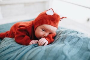 What is gender neutral baby clothing?-Baby wearing cute knitted outfit.