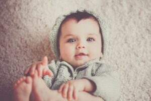 Would you consider renting the baby clothes for a newborn?-Baby in cute knitted outfit.