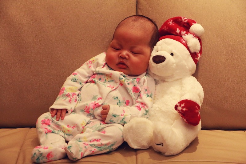 What's Simple Joys by Carter's?-Cute baby leaning against a white teddy bear with closed eyes.