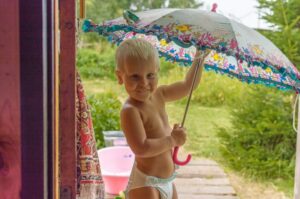 The best eco-friendly nappies in Australia-Little boy wearing a nappy outside while holding a umbrella.