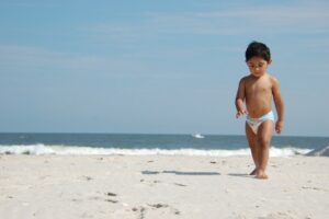 What Biodegradable Nappies in Australia are the Best?-Toddler walking in a nappy on the beach.