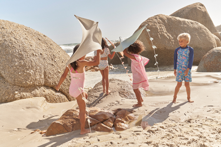 Does Mina Boden have sales. Image of Boden USA of 4 kids on the beach dresses in Boden outfits.