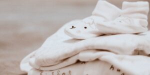 What is the softest fabric for baby clothes?-Pile of baby clothes.