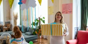 Is the Amazon baby registry box available in Australia?-Pregnant women holding a big box with yellow and with wrapping paper.