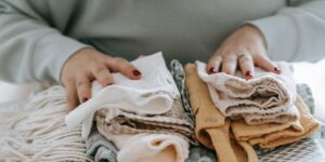 Are Gerber baby clothes in Australia?- Unrecognizable woman with folded clean baby clothes.