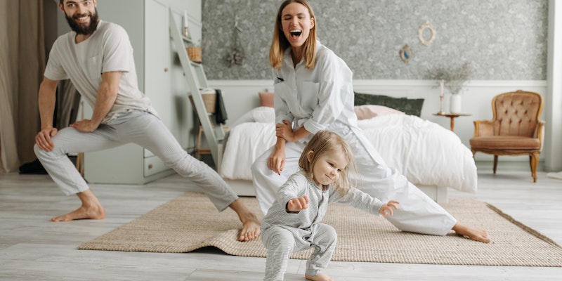 Target baby clothes.-Mum. dad and a child doing exercise in a spacious bedroom.