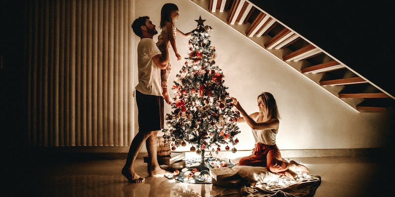Are Hanna Andersson's family Christmas Pajamas worth it?-Image a family decorating their christmas tree.